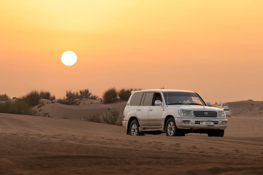 A 4x4 on the sand at sunset