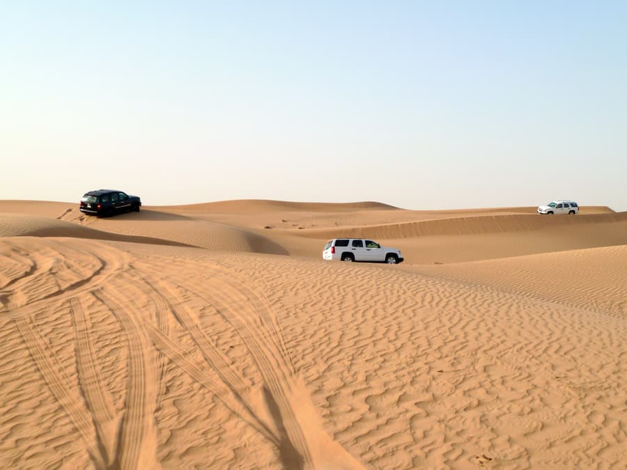 4x4 vehicles spread out across the dunes
