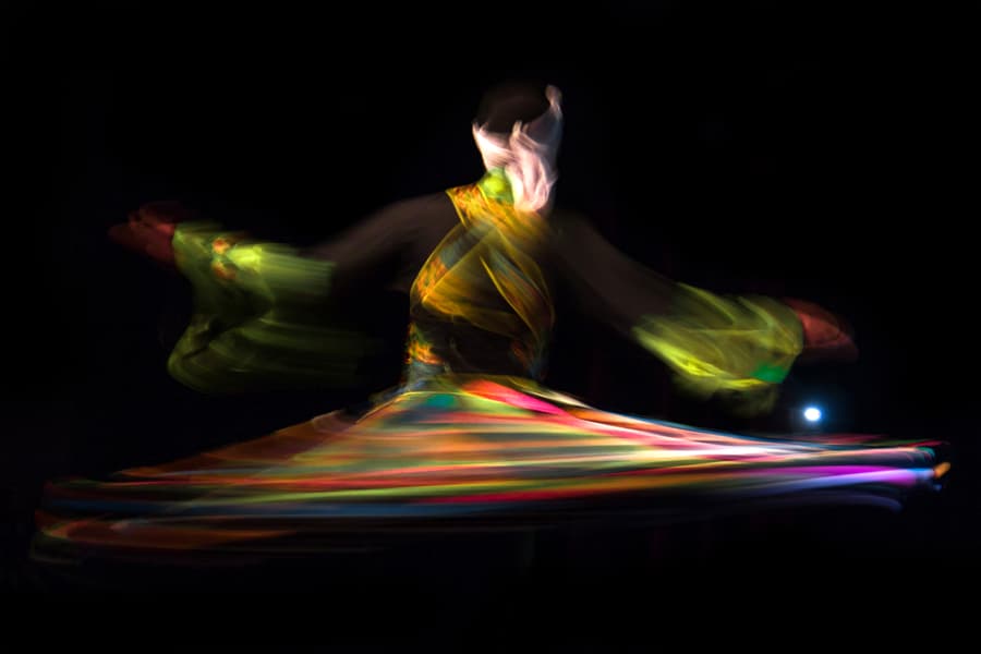 A tanoura dancer spinning in a colourful skirt